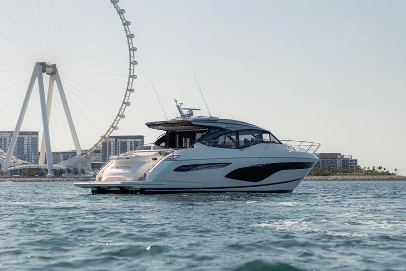  Yacht Photos Pics 2020 Princess V60 yacht cruising near a large Ferris wheel on a sunny day.