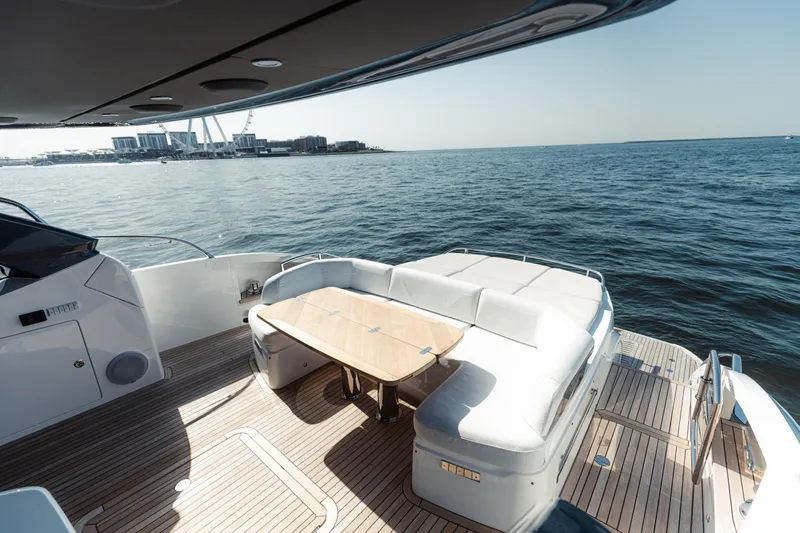  Yacht Photos Pics Luxurious 2020 Princess V60 yacht deck with seating, overlooking serene ocean waters.