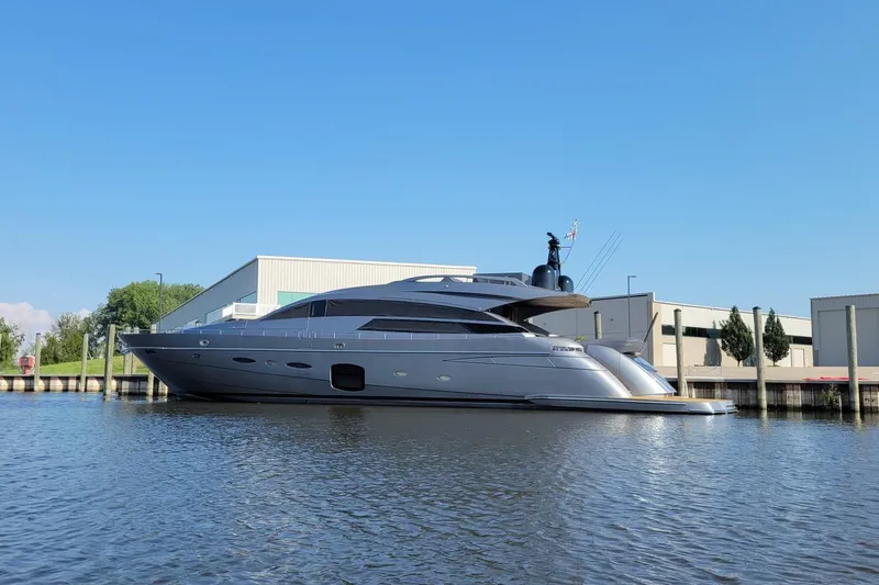 Right Now! Yacht Photos Pics 2017 Pershing 92 Motor Yacht docked by industrial buildings on a sunny day.