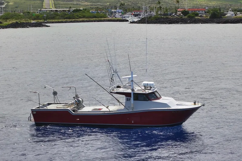  Yacht Photos Pics Custom Hoku 40 boat from 2018 on calm waters near a coastal town.