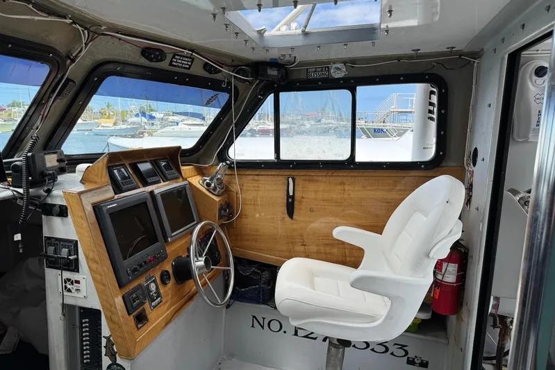  Yacht Photos Pics Interior of 2018 Custom Hoku 40 boat with steering wheel, controls, and white captain's chair.