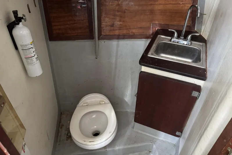  Yacht Photos Pics Compact bathroom with toilet, sink, and fire extinguisher in a 2018 Custom Hoku 40.