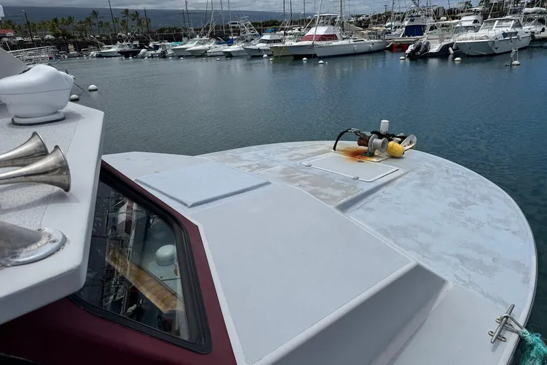  Yacht Photos Pics Bow of Custom Hoku 40 boat in marina, surrounded by other vessels, cloudy sky.