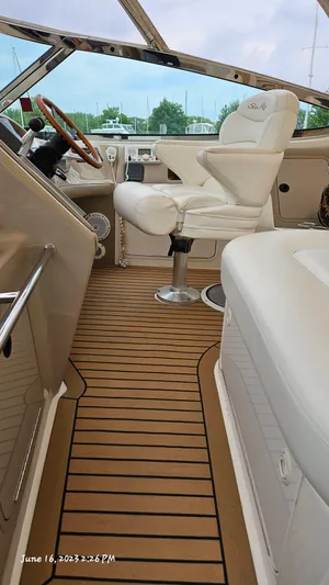 Dolce Vita Yacht Photos Pics Interior of 1999 Sea Ray 540 Sundancer boat with white captain's chair and wooden steering wheel.