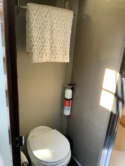  Yacht Photos Pics Compact bathroom in 2018 Carver C52 Coupe with toilet, towel, and fire extinguisher.