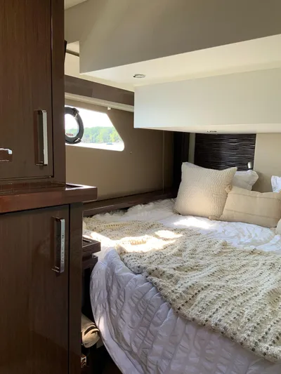  Yacht Photos Pics Interior of 2018 Carver C52 Coupe yacht with cozy bed and elegant wood cabinetry.