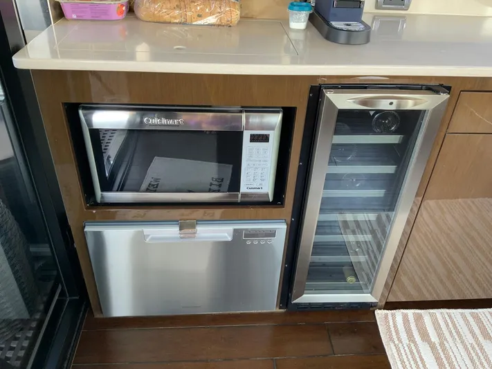  Yacht Photos Pics Modern kitchen appliances in a 2018 Carver C52 Coupe yacht, featuring a microwave and mini fridge.