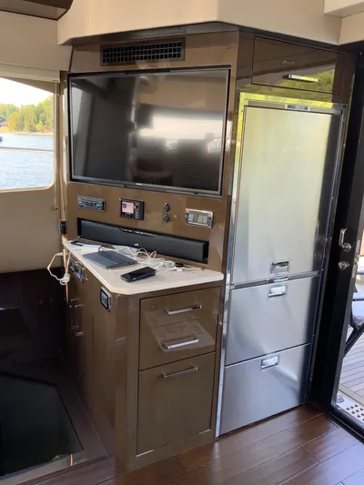  Yacht Photos Pics Interior of 2018 Carver C52 Coupe featuring a TV and stainless steel fridge.
