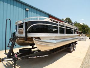 2025 Sun Tracker Sportfish™ 20 DLX pontoon boat on trailer outside blue building.