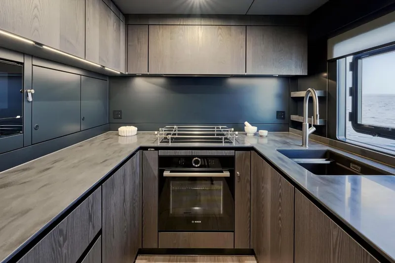  Yacht Photos Pics Modern kitchen interior on 2026 Sunreef 60 Power yacht, featuring sleek cabinetry and ocean view.