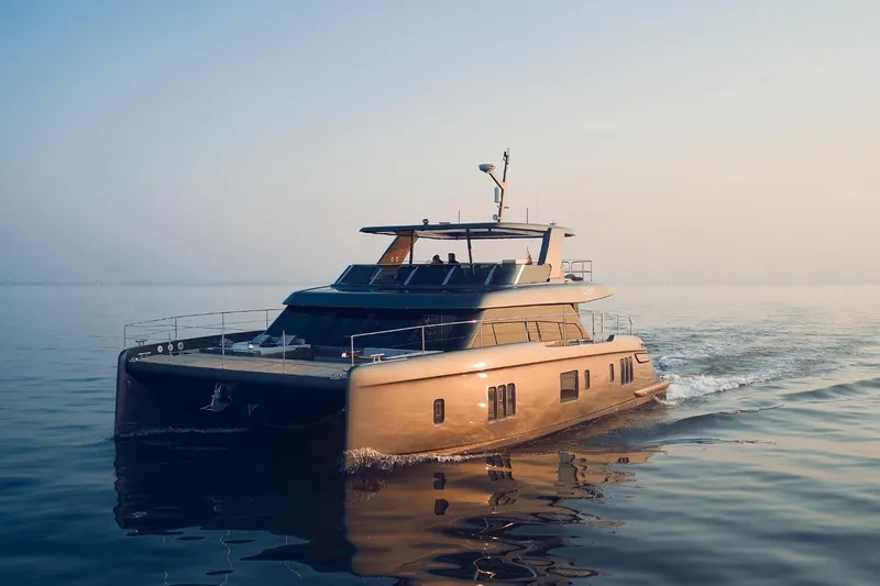  Yacht Photos Pics Luxurious 2026 Sunreef 60 Power yacht cruising on calm waters at sunset.