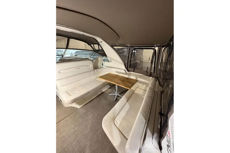 Knot Squared II Yacht Photos Pics 1999 Sea Ray 400 Sundancer interior with white seating and wooden table.