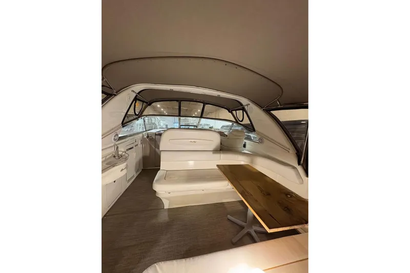 Knot Squared II Yacht Photos Pics Interior of 1999 Sea Ray 400 Sundancer yacht with seating and wooden table.