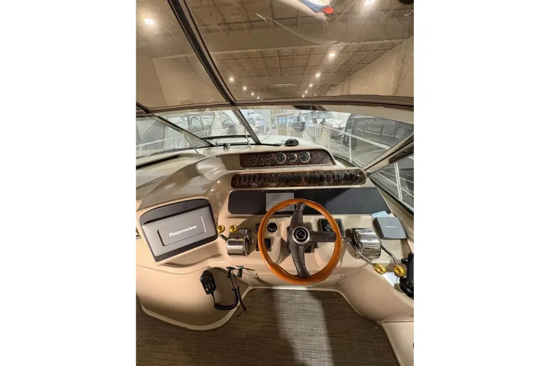 Knot Squared II Yacht Photos Pics 1999 Sea Ray 400 Sundancer helm with steering wheel and navigation controls.