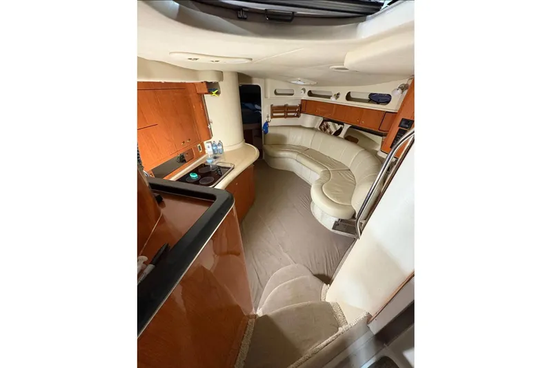 Knot Squared II Yacht Photos Pics 1999 Sea Ray 400 Sundancer interior with curved seating and wooden cabinetry.