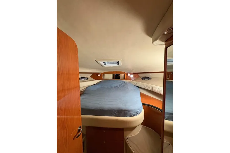 Knot Squared II Yacht Photos Pics 1999 Sea Ray 400 Sundancer cabin interior with bed and wooden accents.