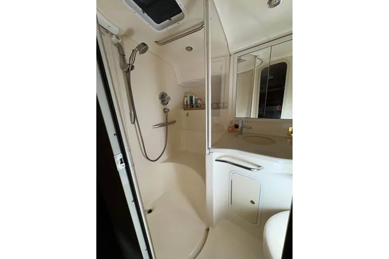 Knot Squared II Yacht Photos Pics 1999 Sea Ray 400 Sundancer bathroom with shower, sink, and mirrored cabinet.