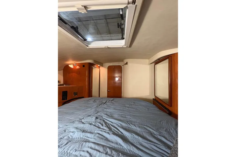 Knot Squared II Yacht Photos Pics 1999 Sea Ray 400 Sundancer cabin interior with bed, skylight, and wooden accents.