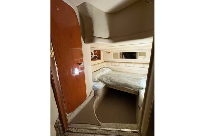 Knot Squared II Yacht Photos Pics 1999 Sea Ray 400 Sundancer cabin interior with bed and wooden door.