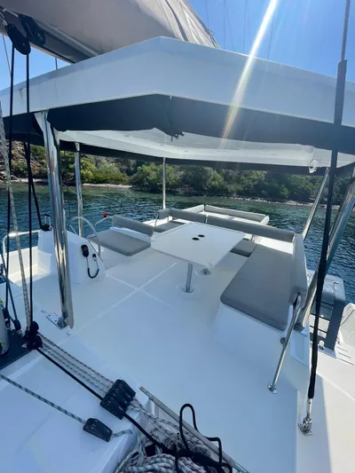  Yacht Photos Pics 2021 Bali 4.8 yacht deck with seating area, table, and scenic water view.