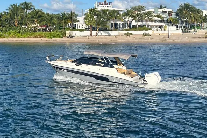  Yacht Photos Pics 2024 Hanover 305 White & Gray Edition boat cruising near a tropical beach.