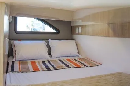  Yacht Photos Pics 2023 Hanover 377 interior with cozy bed, striped bedding, and modern window design.