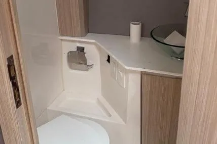  Yacht Photos Pics Compact bathroom in 2023 Hanover 377 model with modern fixtures and wooden accents.