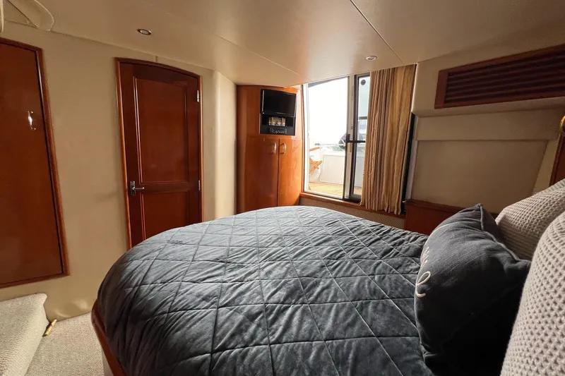  Yacht Photos Pics Luxurious bedroom interior of 2003 Carver 444 Cockpit Motor Yacht with elegant wood finishes.