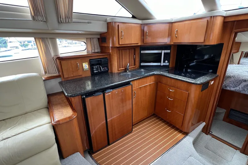  Yacht Photos Pics 2003 Carver 444 Cockpit Motor Yacht interior with kitchen, featuring wood cabinetry and modern appliances.