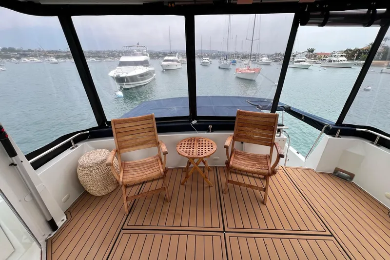  Yacht Photos Pics 2003 Carver 444 Cockpit Motor Yacht with wooden chairs and table, overlooking marina.