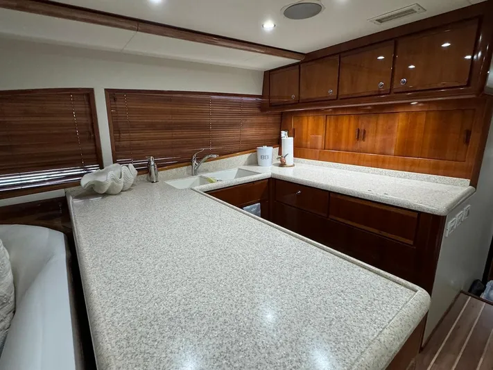  Yacht Photos Pics Luxurious kitchen interior of 2004 Bertram 510 Convertible yacht with wooden cabinets and countertops.
