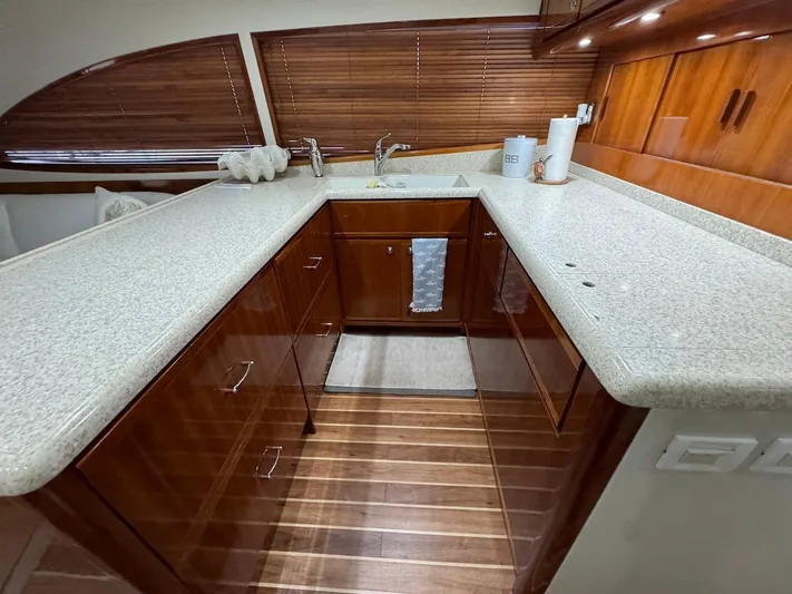  Yacht Photos Pics Luxurious kitchen interior of 2004 Bertram 510 Convertible yacht with wooden cabinets and countertops.