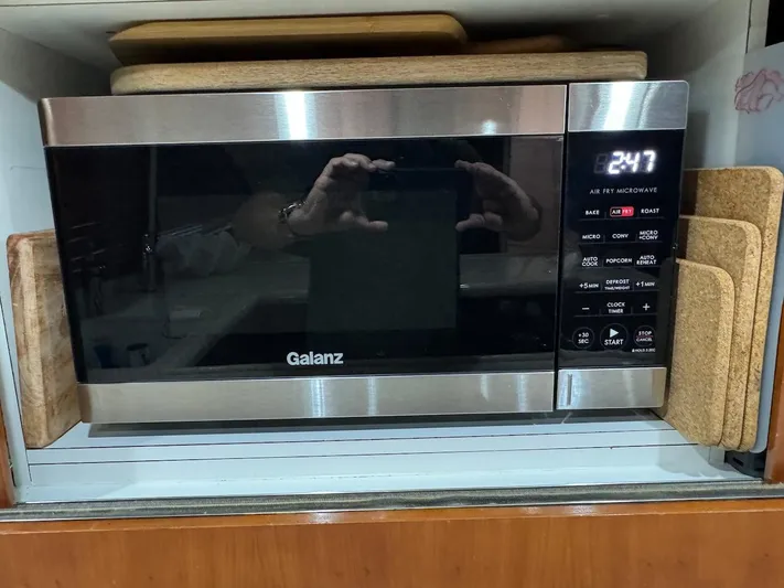  Yacht Photos Pics Galanz microwave oven with digital display, surrounded by cutting boards.