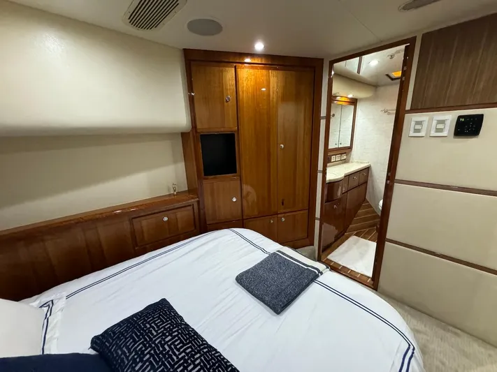  Yacht Photos Pics Luxurious 2004 Bertram 510 Convertible yacht bedroom with wood cabinetry and ensuite bathroom.