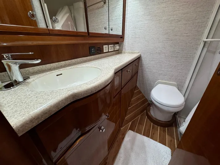  Yacht Photos Pics Luxurious bathroom in 2004 Bertram 510 Convertible yacht with wood accents and modern fixtures.