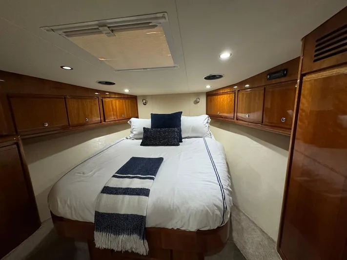  Yacht Photos Pics Luxurious cabin interior of 2004 Bertram 510 Convertible yacht with cozy bed and wooden cabinets.