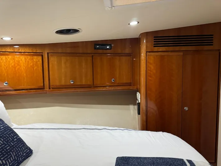  Yacht Photos Pics Interior cabin of 2004 Bertram 510 Convertible yacht with wooden cabinets and bed.