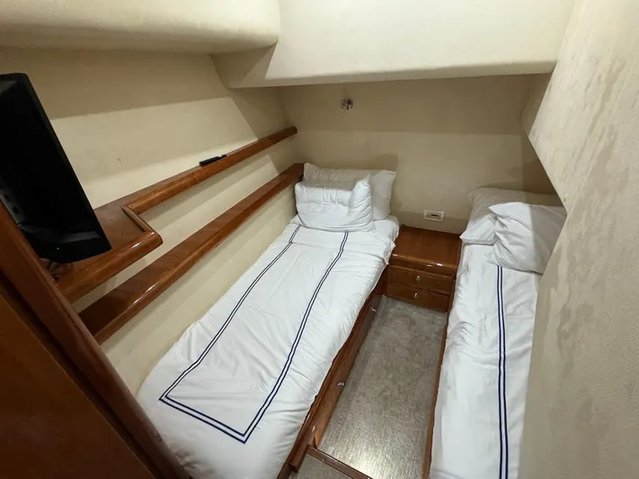  Yacht Photos Pics 2004 Bertram 510 Convertible cabin with twin beds and wooden accents.