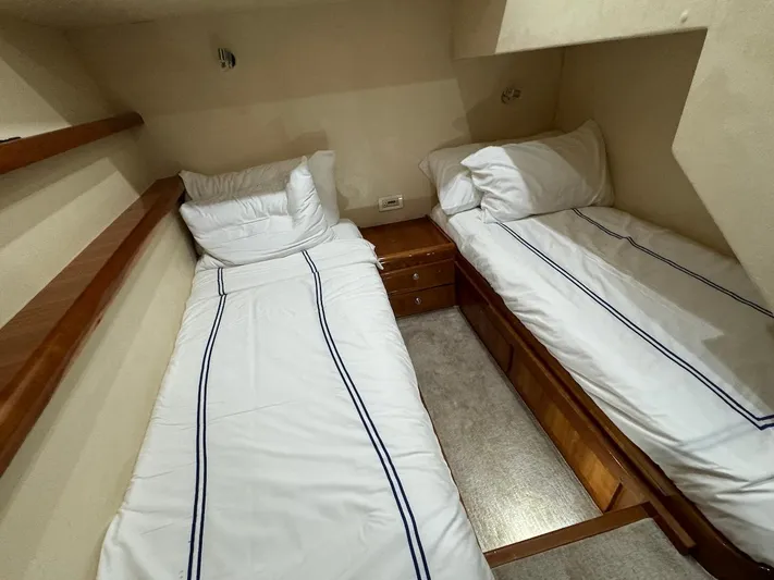  Yacht Photos Pics 2004 Bertram 510 Convertible cabin with twin beds and wooden accents.