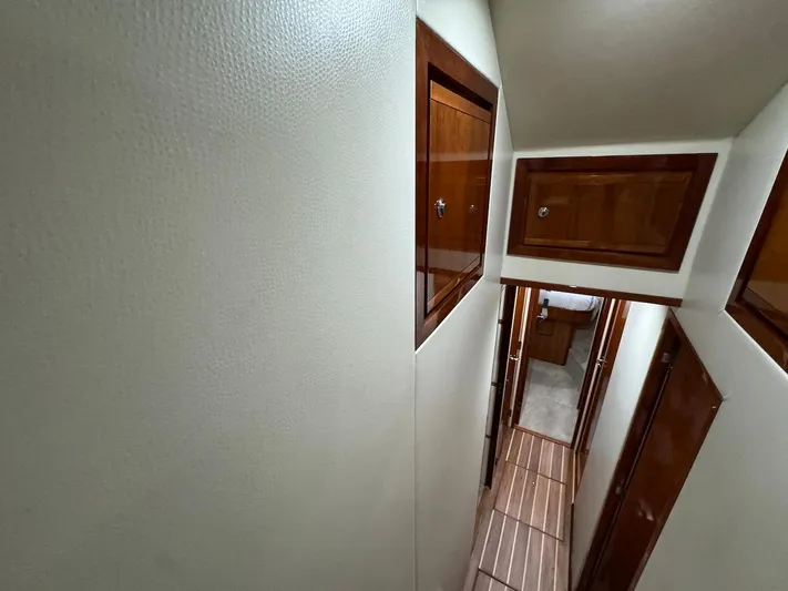  Yacht Photos Pics Narrow hallway inside 2004 Bertram 510 Convertible yacht with wooden cabinets.