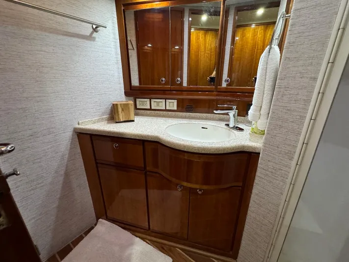  Yacht Photos Pics Luxurious bathroom in 2004 Bertram 510 Convertible yacht with wooden cabinetry and modern fixtures.