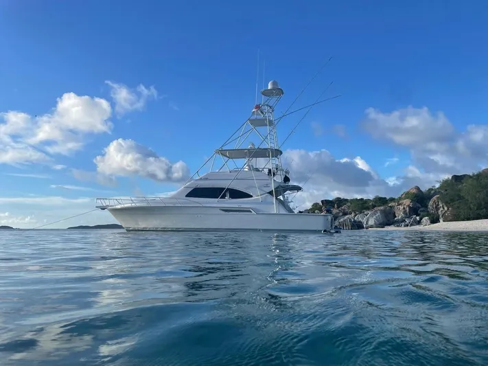  Yacht Photos Pics 2004 Bertram 510 Convertible yacht anchored near a scenic coastline.