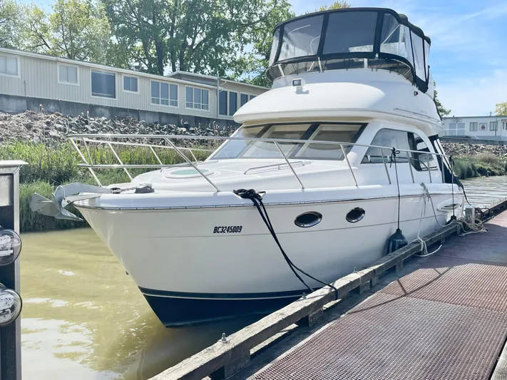  Yacht Photos Pics 2003 Meridian 341 Sedan yacht docked at a marina, surrounded by calm waters.