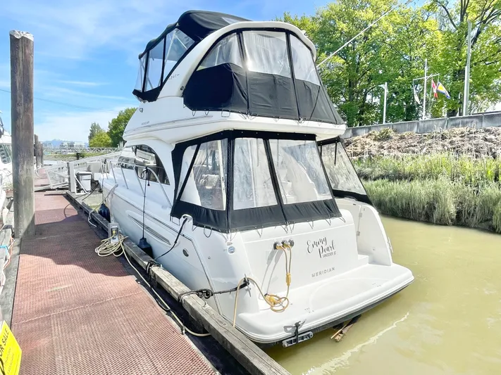  Yacht Photos Pics 2003 Meridian 341 Sedan yacht docked, featuring black canopy and white hull.