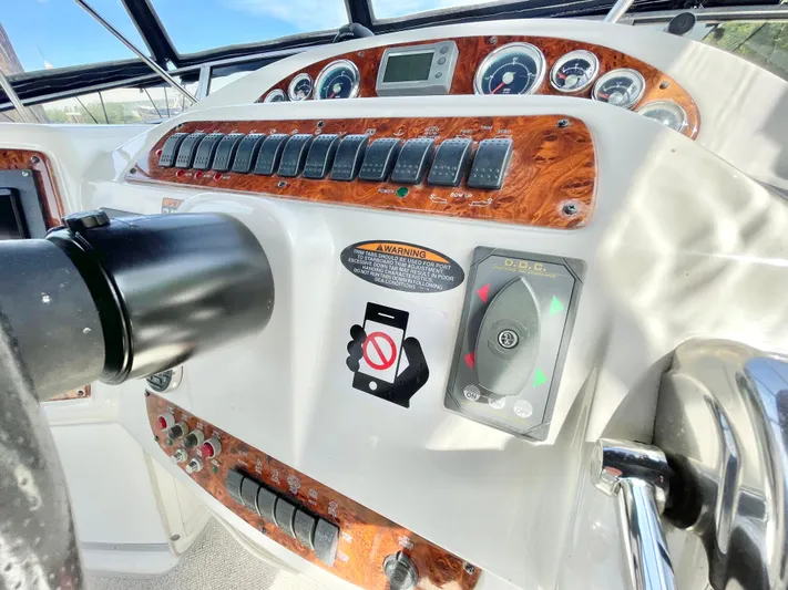  Yacht Photos Pics Control panel of a 2003 Meridian 341 Sedan boat with wood accents and warning stickers.
