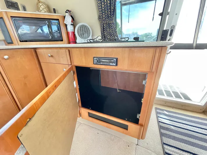  Yacht Photos Pics 2003 Meridian 341 Sedan interior with open cabinet, microwave, and fire extinguisher.