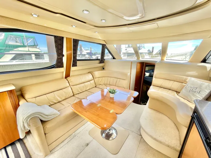  Yacht Photos Pics Luxurious interior of a 2003 Meridian 341 Sedan yacht with beige leather seating and wooden table.