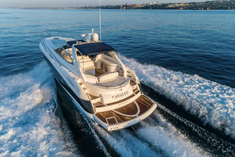 Cavallo Yacht Photos Pics 2004 Sunseeker Portofino yacht cruising on open water, rear view.