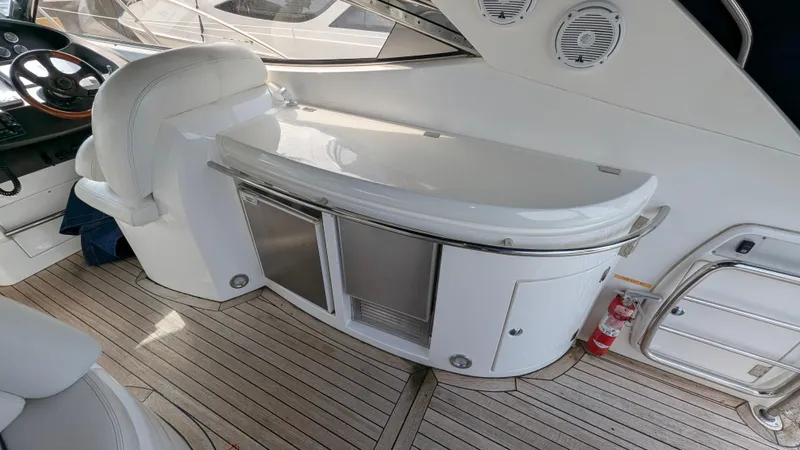 Cavallo Yacht Photos Pics 2004 Sunseeker Portofino yacht interior with sleek white seating and wooden flooring.