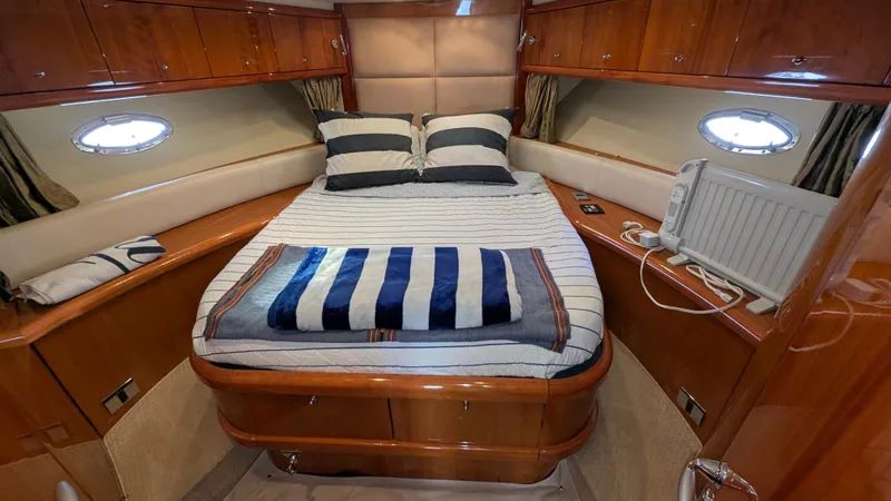 Cavallo Yacht Photos Pics Luxurious cabin interior of 2004 Sunseeker Portofino yacht with cozy bed and elegant wood finish.